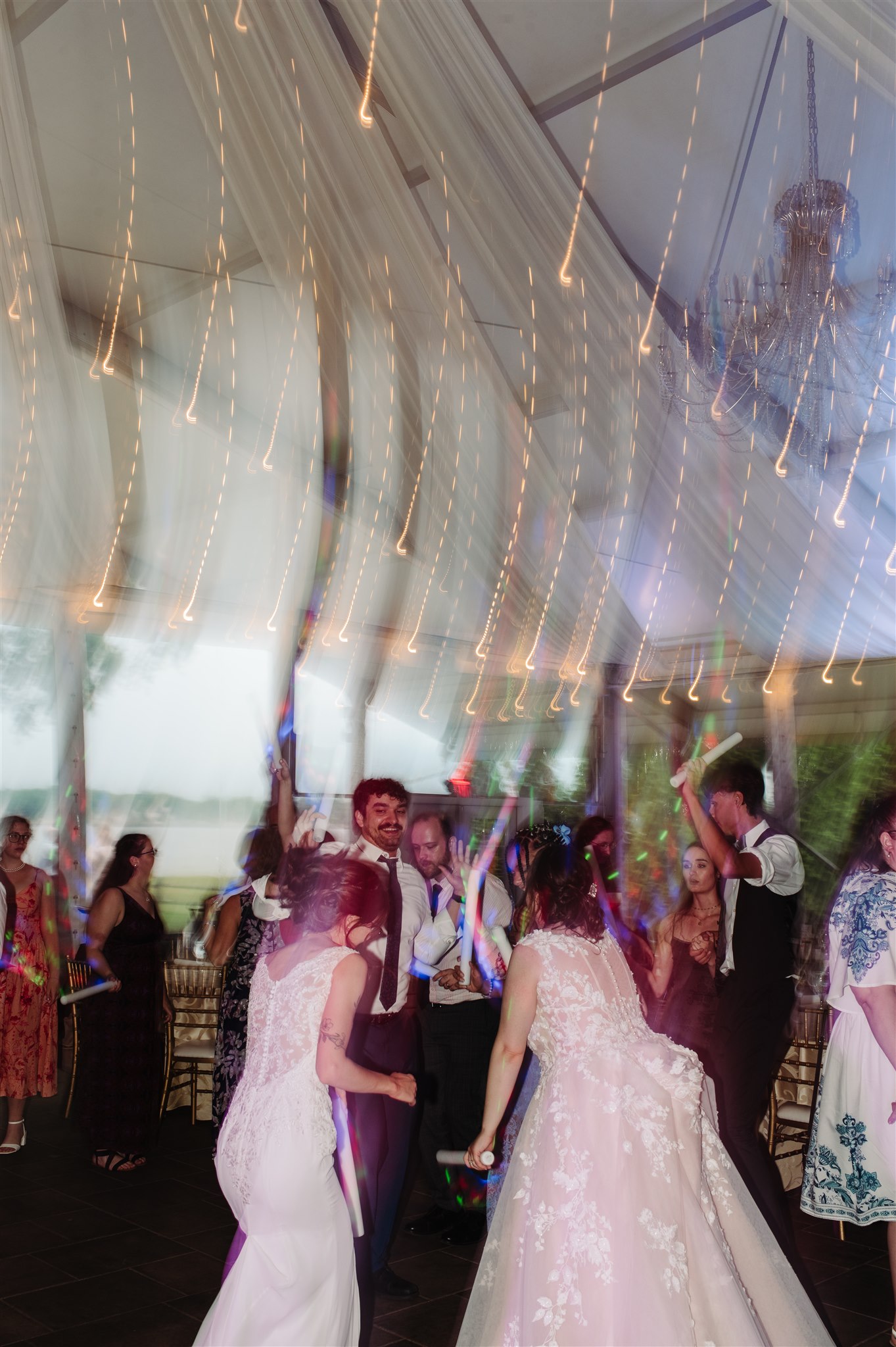 brides embracing by the delaware river at pen ryn estate – breathtaking waterfront wedding photography.