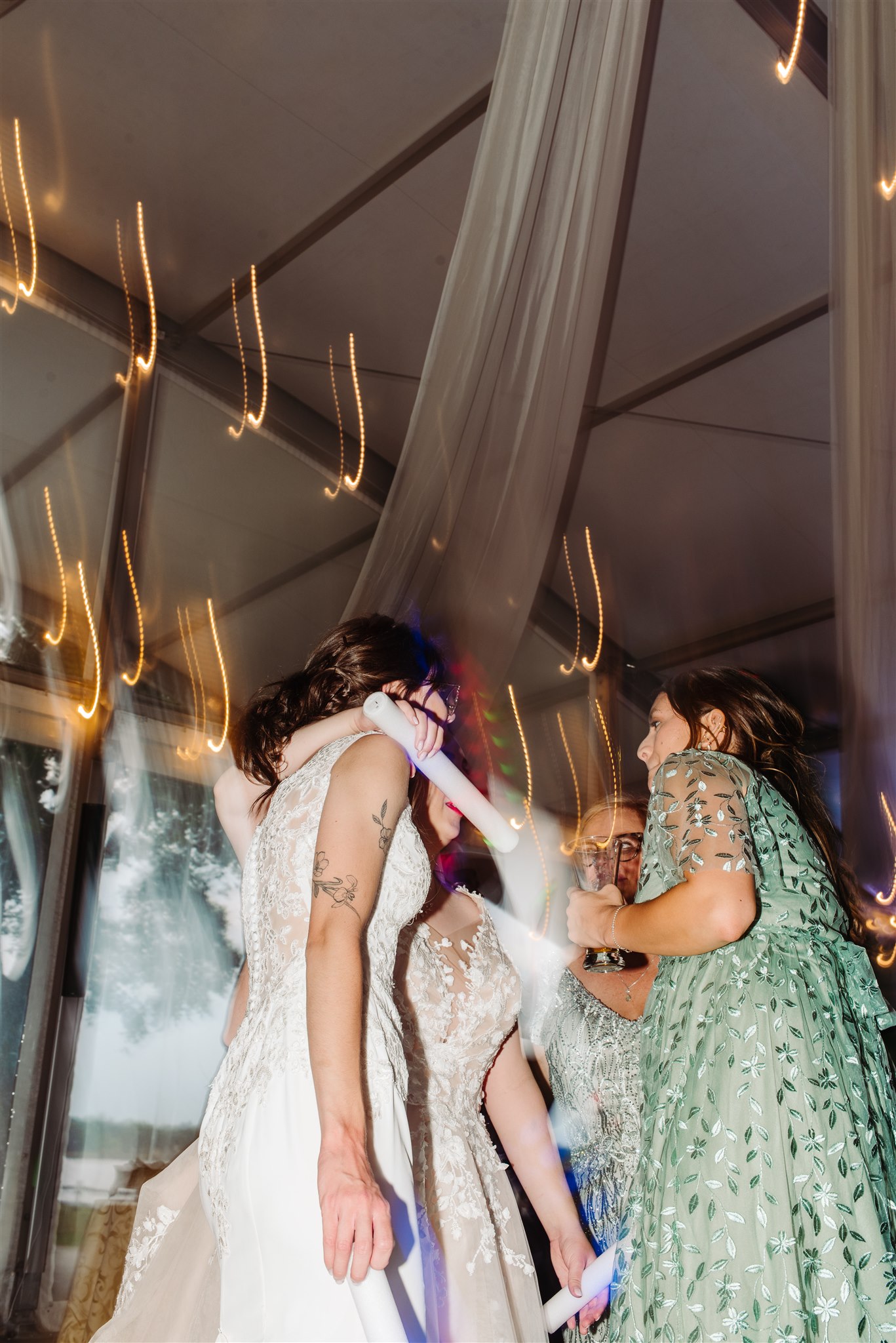 hora dance at a jewish queer wedding in philadelphia – lifting the brides in chairs with guests dancing around them.