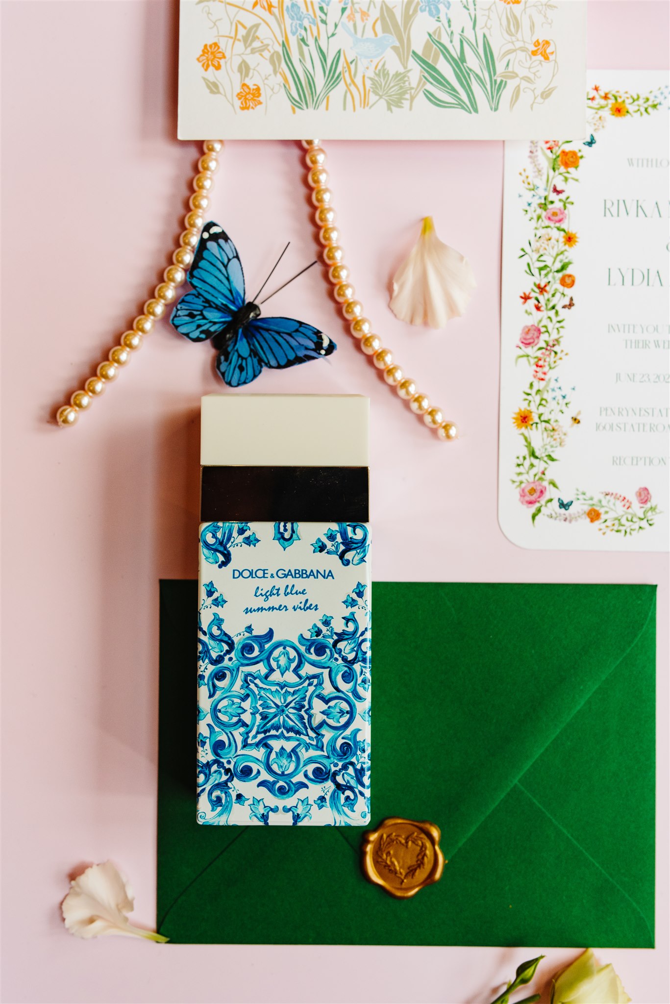 Dolce & Gabbana Light Blue Summer Vibes perfume with a green envelope, blue butterfly, and flowers.