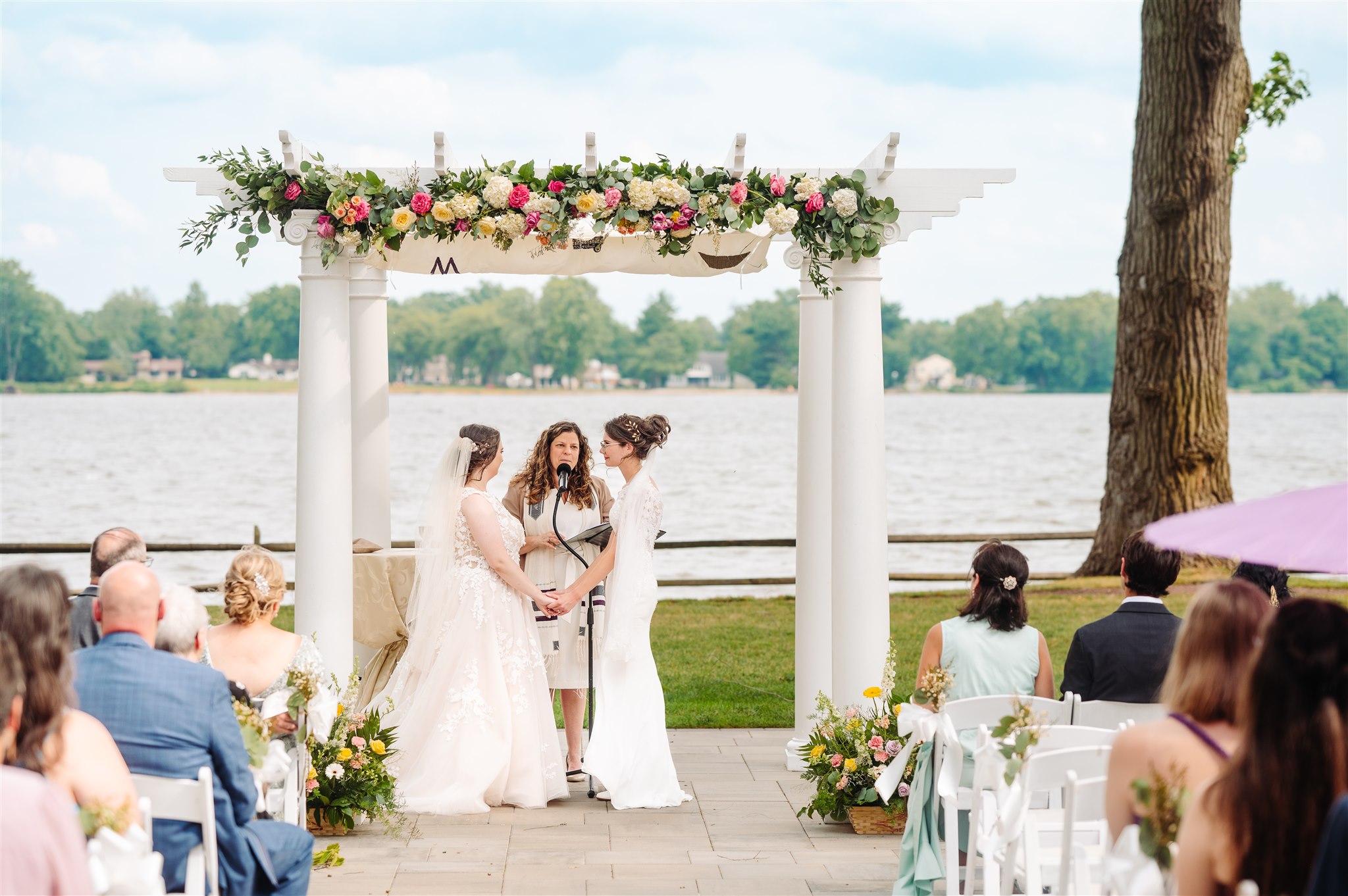 queer newlyweds walking hand in hand along the river – natural and documentary-style wedding photography.