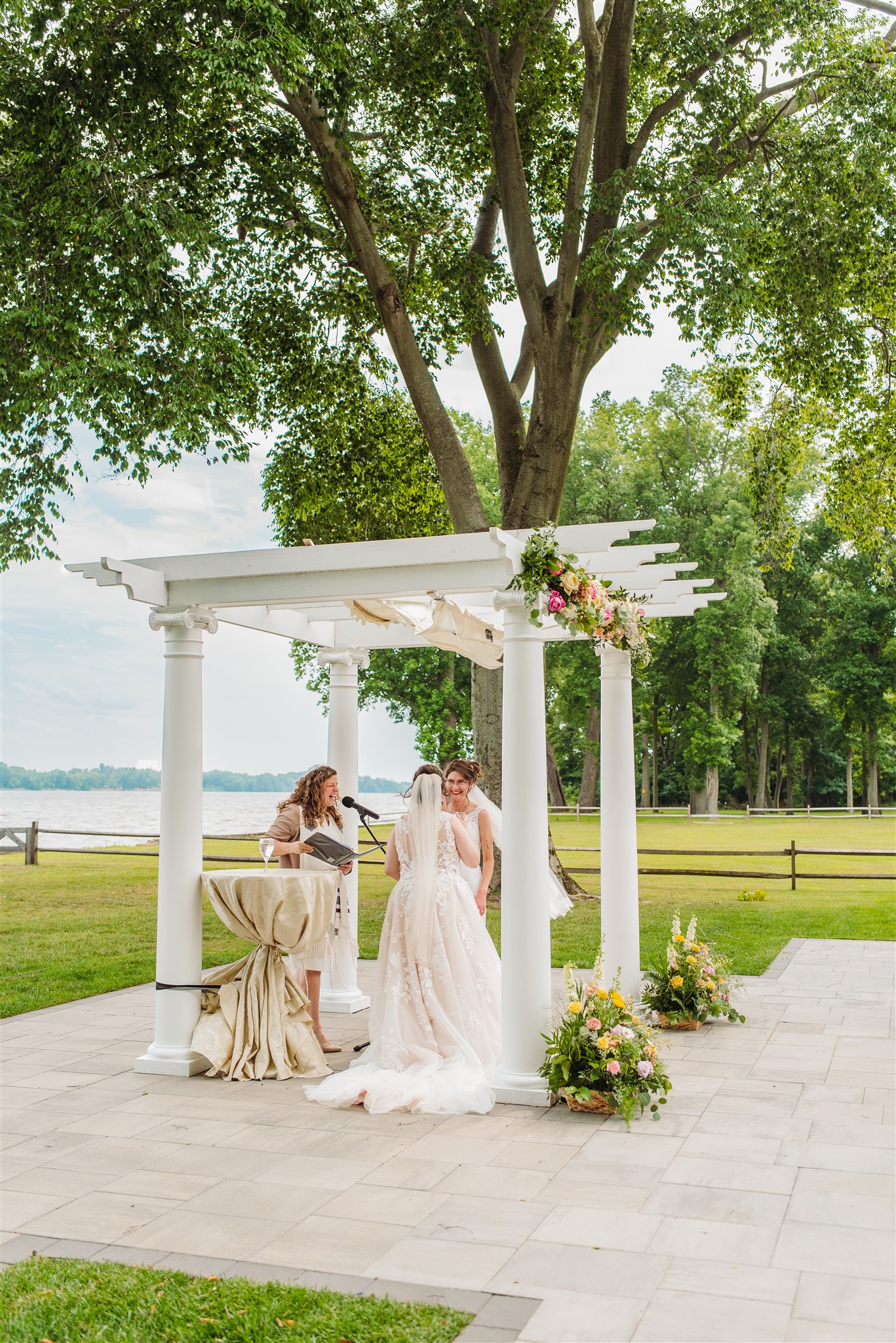 brides sharing a candid laugh on the lawn of pen ryn estate – capturing joy and love in an authentic moment.