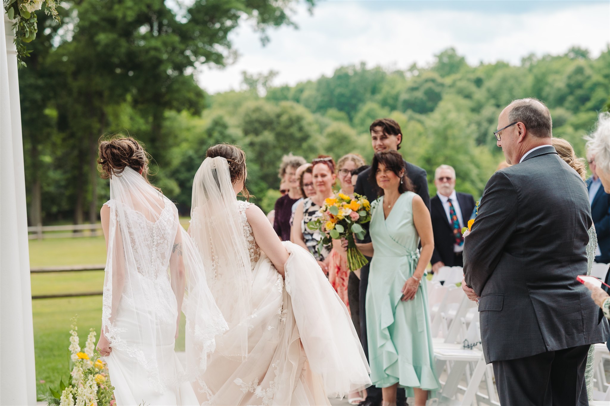 queer jewish wedding ceremony at river's edge pen ryn estate – stunning outdoor ceremony with a floral-adorned chuppah.