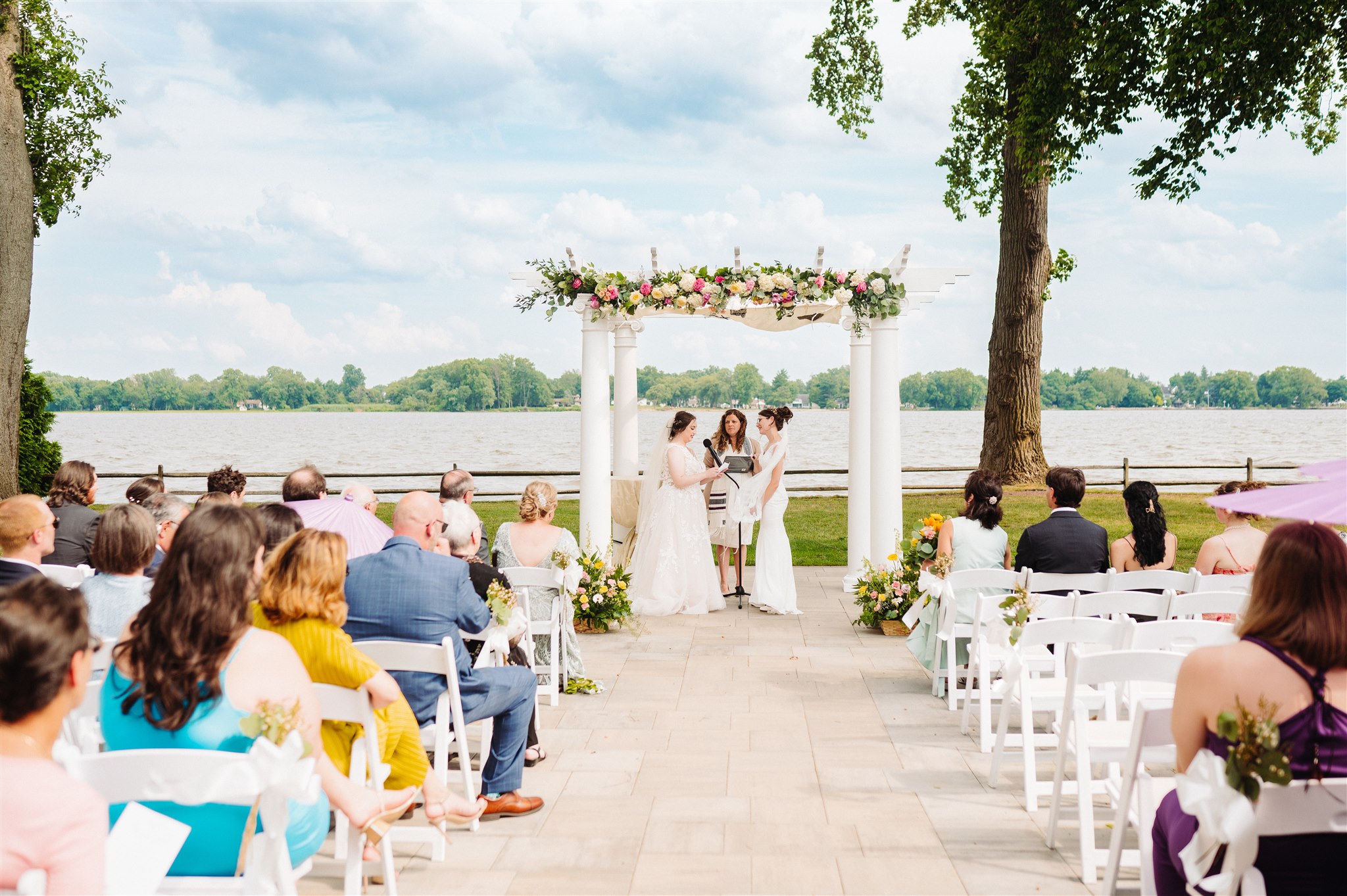 queer couple wrapped in tallit during ceremony: symbolizing their joined lives and faith.